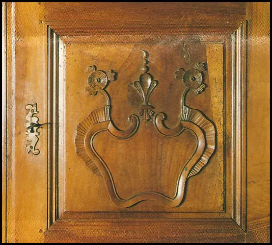 Détail d'un quatre-portes en noyer avec motif Régence ourlé de rubans plissés, fleurs de lis entre marguerites, en l'honneur de la Marguerite des Marguerites, grand-mère de Henri IV Détail d'un quatre-portes en noyer avec motif Régence ourlé de rubans plissés, fleurs de lis entre marguerites, en l'honneur de la Marguerite des Marguerites, grand-mère de Henri IV